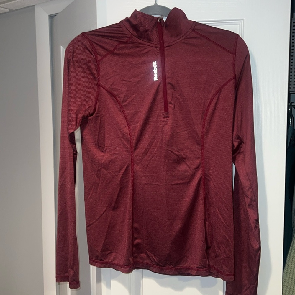 Reebok Women’s quarter zip. Athletic material with thumb holes. Size large.